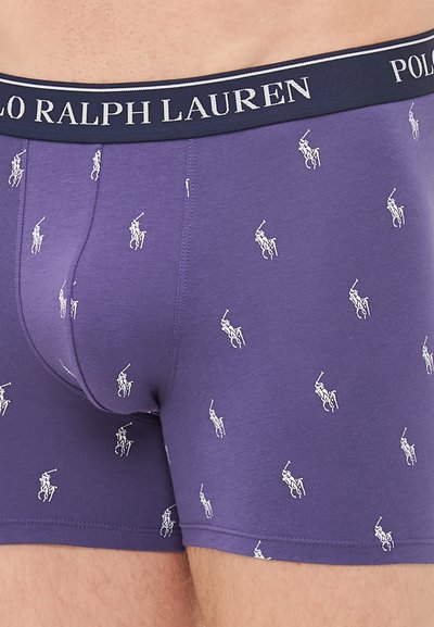 Vijolični moški bokser hlačke z ponavljajočim se belim vzorcem logotipa igralca polo in temno modrim pasom z besedilom 'POLO RALPH LAUREN'.
