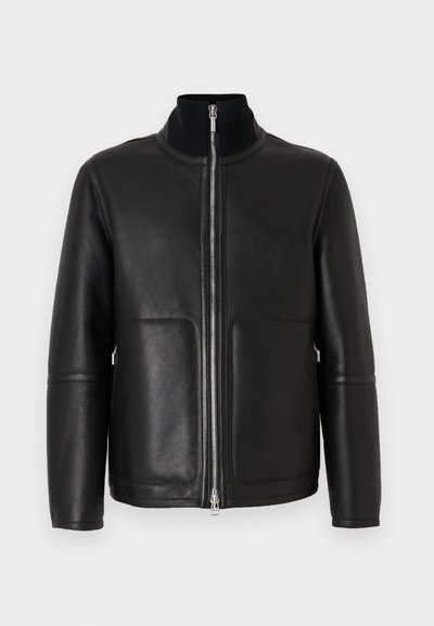 Schwarze Lederjacke mit hohem Kragen, Reißverschluss vorne, zwei Vordertaschen und minimalen Nahtdetails. Glatte Textur und strukturierte Form.