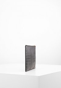 Black leather clutch with a crocodile texture. Slim design, featuring a zip closure and gold-tone hardware. Smooth, durable material.