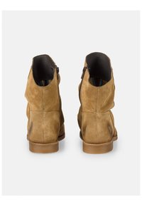 Stivaletti alla caviglia in suede marrone con una texture liscia, dotati di un tacco basso, cerniere laterali e una fodera a strisce colorate.