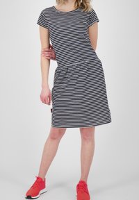 Navy ja valge triibuline T-särk kleit lühikeste varrukatega ja elastse vöökohaga. Kandmise all säravad punased spordijalanõud.