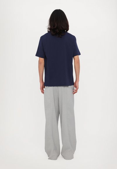 Mørkeblå bomulds t-shirt med korte ærmer, parret med lysegrå wide-leg bukser. Sættet har et enkelt og afslappet design.