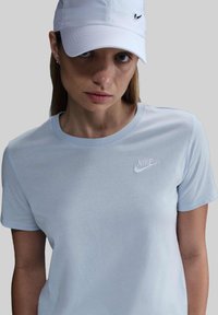 T-shirt Nike azzurro con maniche corte e scollo rotondo. Presenta il logo ricamato sul lato sinistro del petto. Tessuto liscio e elastico.