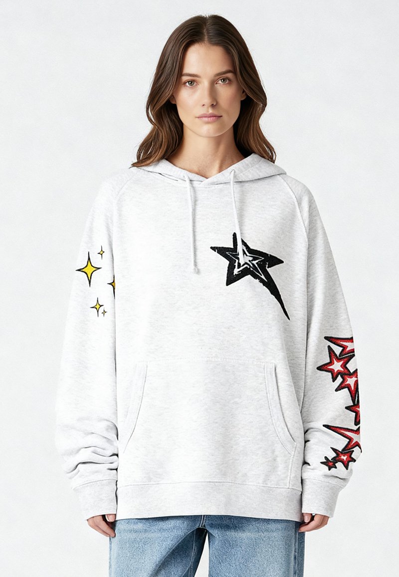 Felpa con cappuccio grigio chiaro in materiale morbido, con stelle nere e rosse stampate sulle maniche e una tasca a marsupio sul davanti.