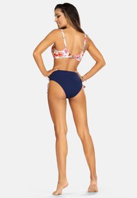 Bikini w kwiatowym nadruku z regulowanymi ramiączkami, w zestawie z jednolitymi, granatowymi majtkami z wysokim stanem. Gładki materiał i dopasowany krój.