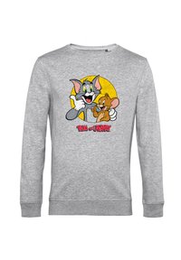Šedá mikina s potiskem kresleného grafiku Toma a Jerryho, s živými barvami a textem "TOM a JERRY" ve spodní části. Hladká textura.