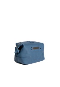Blauwe leren tas met een ritssluiting, rechthoekige vorm, horizontale geperforeerde accenten aan de voorkant en een kort handvat aan de zijkant.