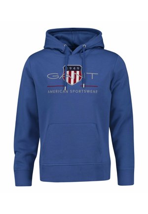 Blauwe capuchontrui met voorzak, trekkoorden en "GANT 1949 American Sportswear" logo met schildontwerp op de borst.