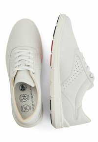 Sneaker bianchi in pelle con design perforato, colletto imbottito e accenti neri e rossi a contrasto sulla suola. Chiusura con lacci, tacco piatto.