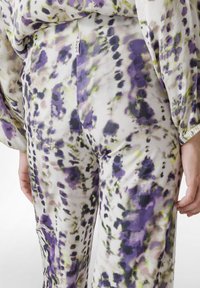 Lichtgewicht broek met een bloemenpatroon in paarse, witte en groene tinten. Opvallend DEHA merklabel aan de zijkant.
