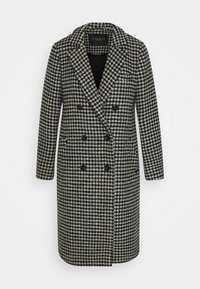 Abrigo de doble botonadura en un patrón de pata de gallo en blanco y negro, con cuello de solapa y dos bolsillos frontales. Fabricado con tejido texturizado.