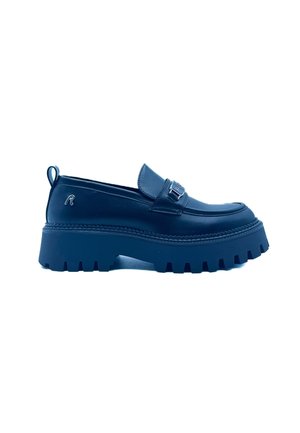 Mocasín tipo plataforma grueso negro con suela gruesa con dibujo, parte superior de cuero, hebilla metálica decorativa y lengüeta en el talón.