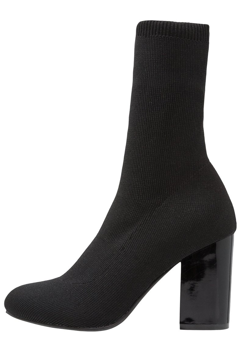 Bottine noire style chaussette avec tissu en maille côtelée et talon bloc haut brillant.
