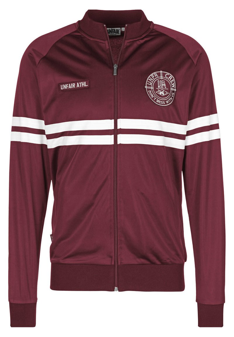 Bordo zip-up striukė pagaminta iš lygios medžiagos. Yra baltos juostelės ir siuvinėjimas krūtinėje, taip patį suglamžyti rankogaliai ir apačia.