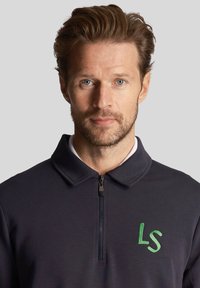 Marine blauwe rits-polo met een kraag, voorzien van een groene geborduurde "LS" logo op de borst, gemaakt van een gladde stof.