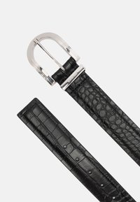 Zwarte leren riem met een krokodillenstructuur, voorzien van een zilveren metalen gesp en meerdere verstelgaatjes langs de band.