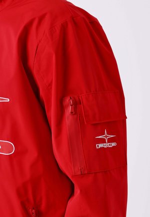 Manica di giacca rossa con tasca con zip e tasca a patta, dotata di logo "PXP" ricamato in bianco e design a stella.