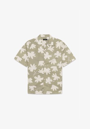 Chemise beige à manches courtes avec un motif abstrait de feuilles blanches, boutonnée à l'avant, et un col style camp.