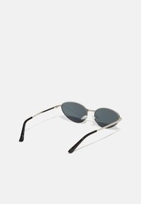 Ochelari de soare rotunzi cu lentile de culoare gri închis, cadru din metal argintiu și brațe din plastic negru. Dispun de tampoane pentru nas pentru confort și un design elegant.