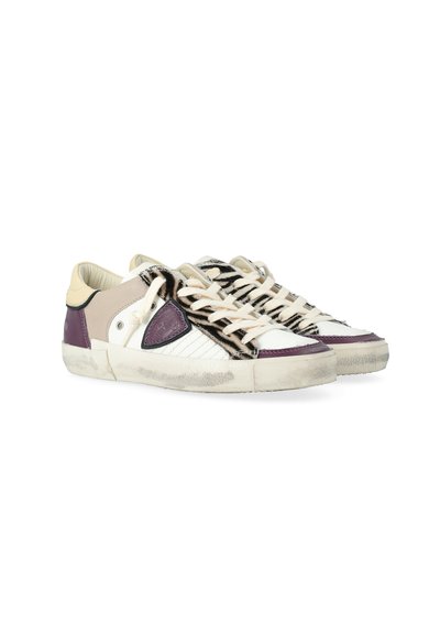 Witte lage sneakers met paarse accenten, beige panelen, een zebra-gestreepte tong en versleten rubberen zolen, gekruid en naast elkaar.