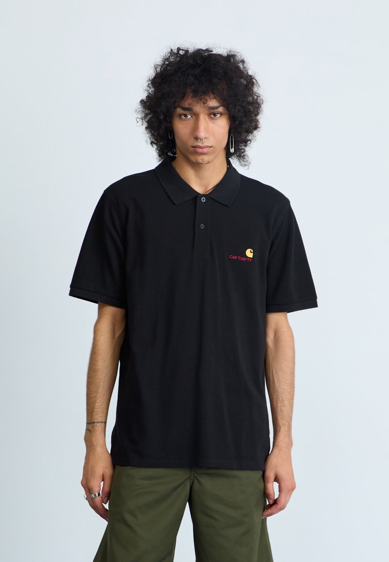Polo noir avec col, manches courtes, et un petit logo "carhartt" rouge sur la poitrine gauche. Fabriqué en tissu de coton respirant.