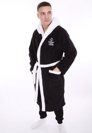 Fleece bathrobe in black with white accents, featuring a shawl collar, tie belt, and two front pockets. Embroidered design on chest.