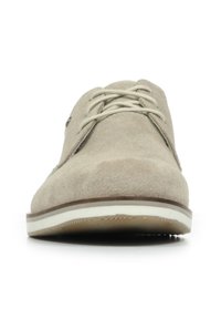 Beige suède schoenen met een ronde neus, witte rubberen zool en katoenen veters; eenvoudig ontwerp met een subtiele textuur en minimale hardwareaccenten.