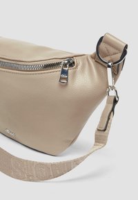 Beige leren schoudertas met zilveren rits en hardware. Heeft een gestructureerd oppervlak en een patroonriem voor extra detail.