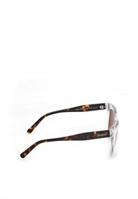 Aurinkolasit, joissa on kirkas ja kilpikonnakuosiset kehykset, ruskeat linssit ja sivuakkenttilogo. Ominaisuuksiin kuuluu leveä, litteä muotoilu ja tekstuuriset varsiosat.