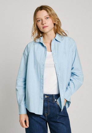 Lichtblauwe button-up shirt met een kraag, lange mouwen en een relaxte pasvorm, gecombineerd met donkere spijkerbroek.