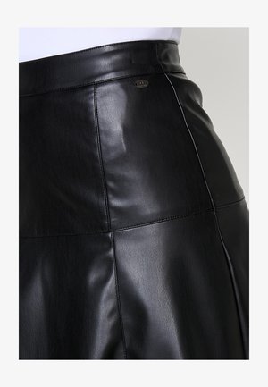 Črna usnjena krilo z gladko teksturo, visokim pasom, vidnimi šivi in kovinsko oznako na pasu.