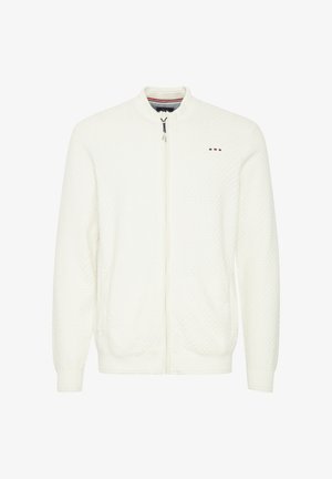 Chaqueta blanca de punto con cremallera y cuello alto, patrón texturizado, dos bolsillos laterales y pequeño detalle de logo de color en el pecho.