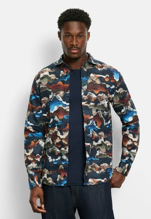 Long-sleeve button-up shirt featuring a multicolored abstract pattern in blue, brown, green, and cream on a navy background.