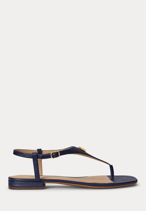 Flad sandal i marineblå med tåremme, justerbar spænde, lav hæl og gyldent dekorativt element på T-rem.