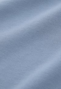 Lichtblauwe stof met een gladde textuur, voorzien van een fijn gebreid patroon. Zacht en flexibel, geschikt voor kleding of bekledingsdoeleinden.