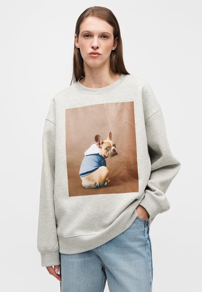 Felpa grigia con una grande stampa di un cane con una felpa con cappuccio blu. Tessuto morbido, design oversize e vestibilità comoda. Maniche lunghe con polsini a costine.