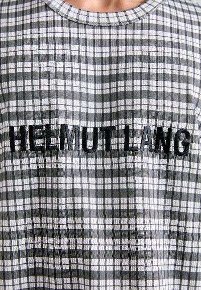 T-shirt en tissu checké gris et blanc avec un col rond et le texte brodé "HELMUT LANG" en lettres noires en gras.