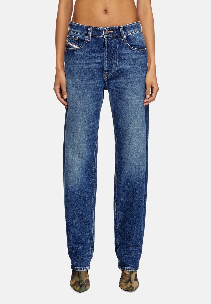 Jeans in denim blu con una vestibilità rilassata, caratterizzati da un design tradizionale a cinque tasche, zip anteriore e aree sbiadite per un effetto usurato.