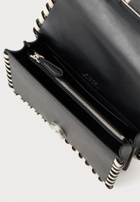 Crna kožna novčanica s srebrnim detaljima, koja sadrži zatvoren odjeljak s patentnim zatvaračem i prepoznatljivim prugastim ukrasima duž rubova.