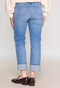 Ljus tvättade denimjeans med rak passform, med uppvikt nederkant, bakfickor och en slät yta. Midjan har bältesöglor.