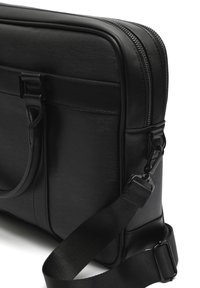 Sort laptop taske med en tekstureret overflade, dobbelte lynlåse, justerbar rem og et robust håndtag. Omfatter slanke, minimalistiske designelementer.