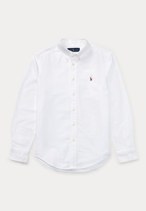 Cămașă albă cu guler tip button-down, confecționată din bumbac. Are mâneci lungi, un guler ascuțit și un mic emblema brodată pe pieptul stâng.
