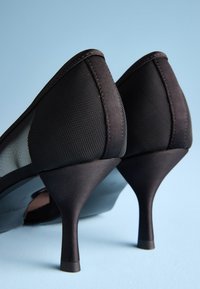Black high heel shoes with a mesh upper and satin accents, featuring a pointed toe and slender stiletto heel.