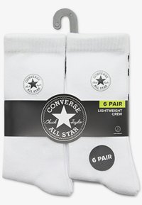 Six pairs of white crew socks, made of lightweight material, featuring a black Converse All Star logo and a hangtag for display.