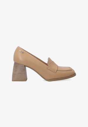 Mocassins en cuir beige avec un bout rond et un détail de couture bien visible. Le talon carré à rayures ajoute de la hauteur et de la stabilité.