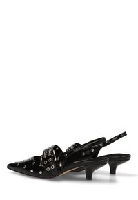 Zapatos de tacón kitten de piel negra con tiras traseras, con ojales plateados y un gran adorno de hebilla en la punta.