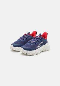 Blauwe mesh sneakers met rode accenten, voorzien van een witte chunky zool en contrasterende gele veters, gemarkeerd met "GEOX" branding.