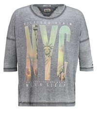 Maglietta grigia a maniche corte con una vestibilità ampia, caratterizzata da una grafica della Statua della Libertà e il testo "NYC NEVER SLEEP" in colori vivaci.