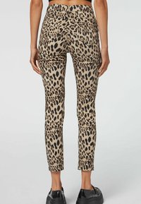 Jeans skinny a stampa leopardata in beige e nero, con vita alta, tasche posteriori e vestibilità slim. Tessuto dalla texture liscia.