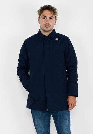 Giacca blu navy a maniche lunghe con collo e chiusura a scatto. Presenta un piccolo logo sul petto sinistro e tasche laterali.